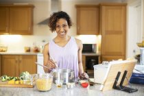 Porträt einer selbstbewussten Frau, die in der Küche kocht — Stockfoto