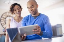 Glückliches Paar nutzt digitales Tablet zu Hause — Stockfoto