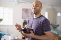 Retrato del hombre seguro comiendo en casa - foto de stock