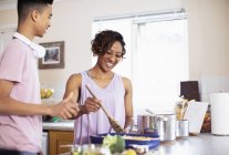 Mother and teenage son cooking in kitchen — Stock Photo