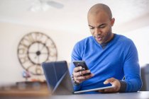Man using digital tablets and smartphone at home — Stock Photo