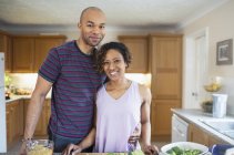 Portrait smiling couple cooking in kitchen — Stock Photo