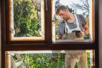 Pittore maschio pittura casa finestra esterna assetto — Foto stock