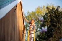 Мужчина живописец на лестнице живопись дома экстерьер — стоковое фото
