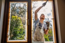 Pintor masculino pintura casa exterior ventana ajuste - foto de stock