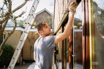 Pittore maschio pittura casa finestra esterna assetto — Foto stock