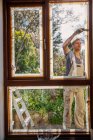 Художник-мужчина расписывает наружное окно дома — стоковое фото