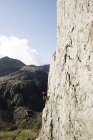 Скалолаз, взбирающийся на большую скалу — стоковое фото