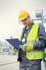 Dock worker with clipboard at shipyard — Stock Photo