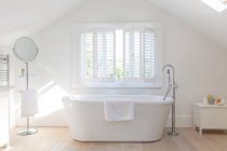 Tranquille salle de bain vitrine blanche avec baignoire trempante — Photo de stock