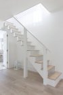 Простые белые и деревянные лестницы в фойе дома витрины — стоковое фото