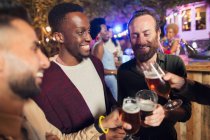 Male friends drinking beers at garden party — Stock Photo