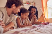 Junge Familie Färbung auf Bett — Stockfoto