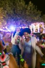 Счастливые друзья танцуют и пьют на вечеринке в саду — стоковое фото