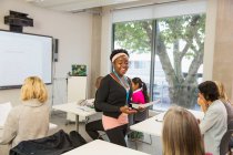 Sorrindo feminino comunidade instrutor universitário lição de liderança em sala de aula — Fotografia de Stock