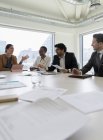 Uomini d'affari che discutono di scartoffie in sala conferenze — Foto stock