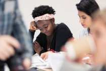 Female community college students reviewing paperwork in classroom — Stock Photo