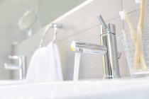 Eau qui coule du robinet de salle de bain en acier inoxydable — Photo de stock