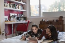 Teenager-Freundinnen lernen Hausaufgaben im Bett — Stockfoto