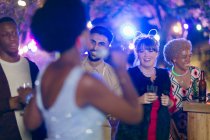 Счастливые друзья пьют и поют караоке на вечеринке в саду — стоковое фото