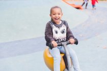 Портрет улыбается, восторженная девушка играет на детской площадке — стоковое фото