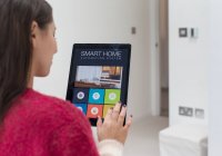 Женщина с использованием интеллектуальной системы домашней автоматизации с цифровым планшетом — стоковое фото
