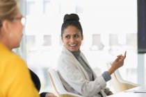 Усміхнена бізнес-леді розмовляє на зустрічі — стокове фото