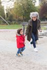 Grandmother and grandson running in park — Stock Photo