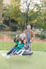 Nonni e nipoti che giocano sull'altalena dei pneumatici nel parco — Foto stock