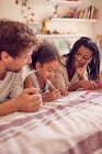 Coloriage jeune famille sur le lit — Photo de stock