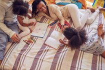 Coloriage jeune famille sur le lit — Photo de stock