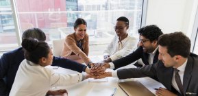 Business people joining hands in conference room meeting — Stock Photo