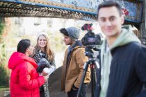 Jóvenes adultos vlogging bajo puente urbano - foto de stock
