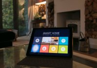 Sistema de domótica inteligente en tableta digital en sala de estar - foto de stock