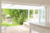 Home showcase kitchen open to summer patio and garden — Stock Photo