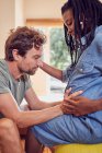 Affectionate husband touching wifes pregnant belly — Stock Photo