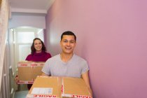 Портрет счастливой пары движущегося дома, с картонными коробками в коридоре — стоковое фото