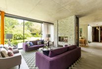 Sala de estar moderna com lareira de tijolo e vista para o jardim — Fotografia de Stock