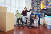 Happy friends taking a break from moving, celebrating, high-fiving in living room — Stock Photo