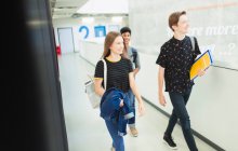 Estudiantes de secundaria caminando por el pasillo - foto de stock