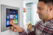 Mann stellt Smart-Home-Navi-Alarm am Touchscreen — Stockfoto