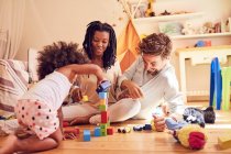 Junge Familie spielt mit Holzklötzen — Stockfoto