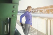 Jovem corredor feminino alongamento perna — Fotografia de Stock
