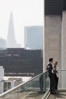 Gente de negocios hablando en soleado, balcón urbano, Shoreditch, Londres - foto de stock