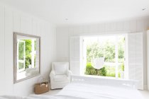 Branco, tranquilo casa vitrine quarto aberto ao pátio ensolarado com rede — Fotografia de Stock