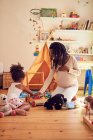 Pregnant mother and toddler daughter playing with toys — Stock Photo