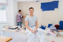 Portrait happy man painting with friends — Stock Photo