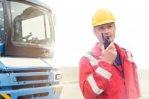 Dock worker using walkie-talkie outside truck at shipyard — Stock Photo
