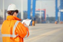 Female dock worker with clipboard at shipyard — Stock Photo