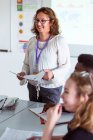 Lächelnde Gymnasiallehrerin leitet Unterricht im Klassenzimmer — Stockfoto